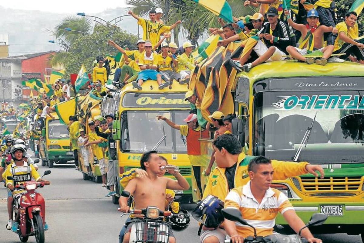 Aunque fue muy colorida la caravana que organizaron los seguidores del Atlético Bucaramanga, se notó enormemente la falta de control de las autoridades. En la fotografía se evidencia cómo los jóvenes se ubicaron en el techo de los buses sin ninguna seguridad, pudiendo ocasionar una tragedia; además, uno de los hinchas conduce una motocicleta mientras ingiere licor. ¿Y la Policía? (Foto: Nelson Díaz / VANGUARDIA LIBERAL)