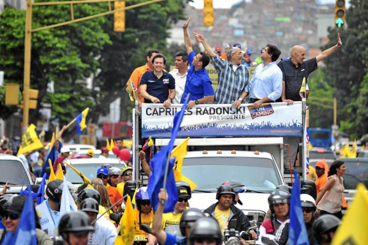 Henrique Capriles (azul sobre el vehículo) aseguró hoy que no es un Mesías. (Foto: AFP/VANGUARDIA LIBERAL)