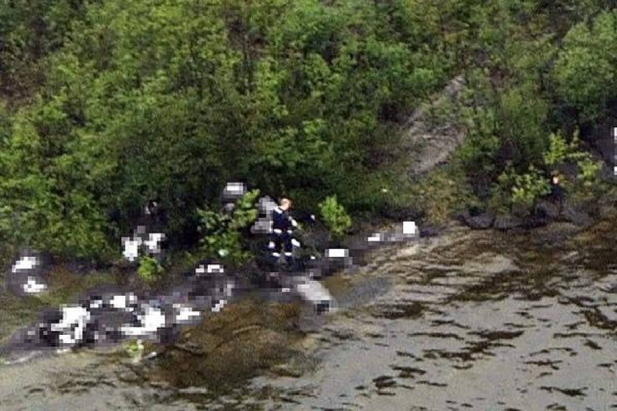 Imagen tomada desde un helicóptero que muestra, según cree la policía noruega, al presunto autor del tiroteo en el campamento juvenil socialdemócrata de la isla de Utoya, Anders Behring Breivik (c), armado junto a varios cuerpos en la orilla del la isla, el 22 de julio de 2011, en el momento de la matanza.(Foto: Efe)