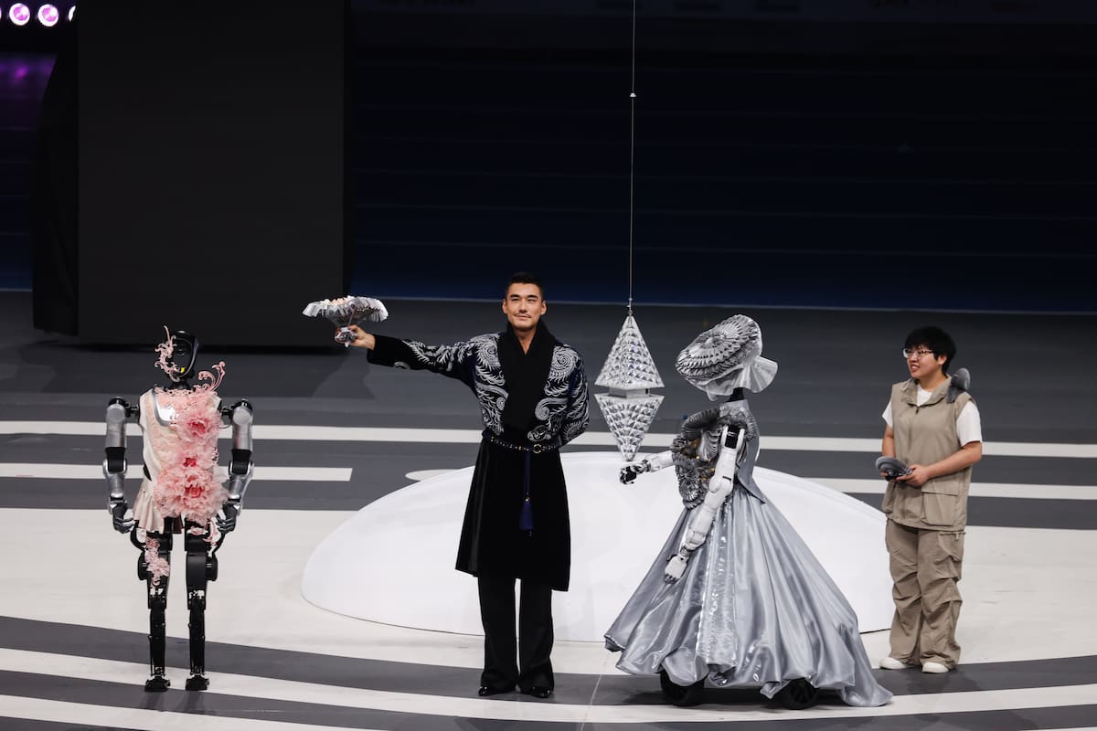 BEIJING (China), 14/08/2025.- Fashion model Hu Bin (2-L) poses for a photo with humanoid robots during the 2025 World Humanoid Robot Games opening ceremony at the National Speed Skating Oval in Beijing, China, 14 August 2025. The 2025 World Humanoid Robot Games will take place over three days from 15 to 17 August. (Moda) EFE/EPA/WU HAO