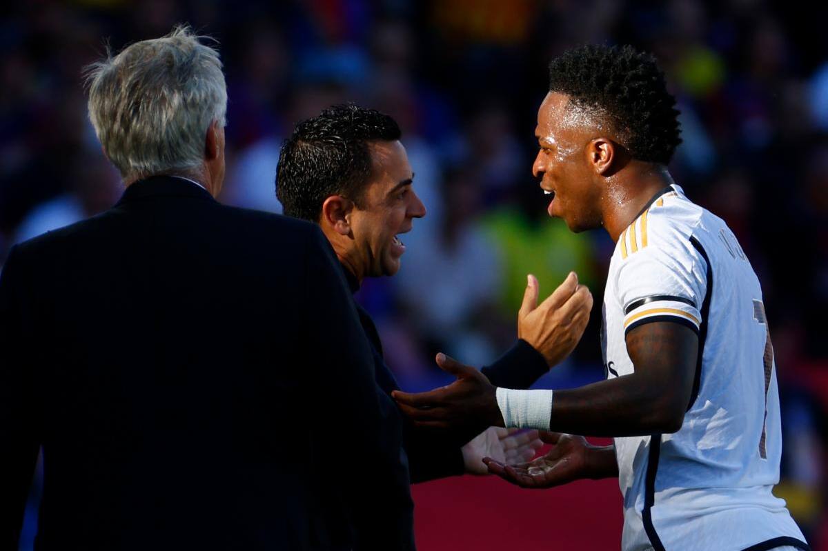 Xavi Hernández (c) habla con Vinícius Júnior ante la mirada de Carlo Ancelotti.//EFE